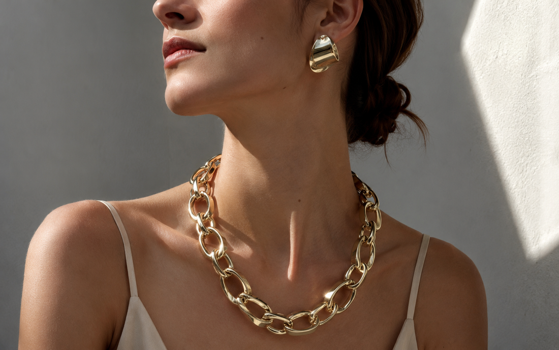 Model styling bold statement jewelry with a simple neutral outfit