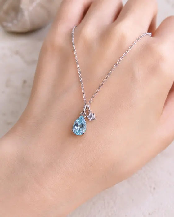 December Blue Topaz Birthstone Teardrop Necklace by ZodiGlow, topaz blue clear necklace, angle view