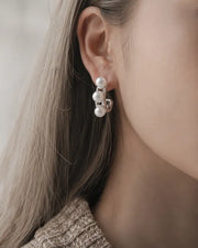 Detail view of Élodie Pearl Sculptural Hoop Earrings by Zodiglow