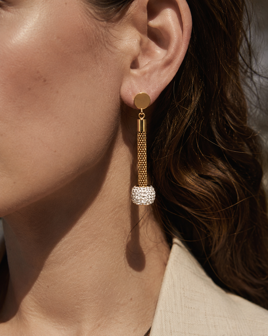 Close-up view of Lumière Gold Pavé Tassel Drop Earrings by Zodiglow